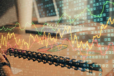 Double exposure of financial graph drawings and desk with open notebook background. Concept of forex marketの写真素材