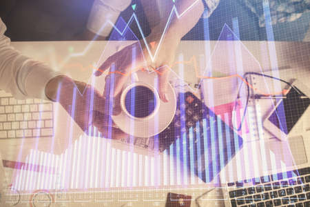 Double exposure of man and woman working together and financial chart hologram drawing. market analysis concept. Computer background. Top View.の写真素材
