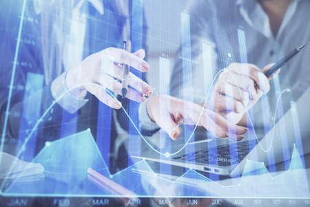 Multi exposure of man and woman working together and financial chart hologram. Business concept....