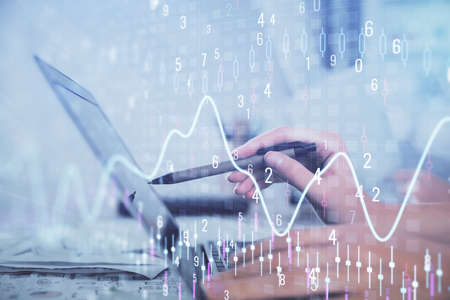 Multi exposure of woman hands typing on computer and financial graph hologram drawing. Stock market...