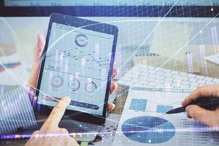 Multi exposure of mans hands holding and using a phone and financial chart drawing. Market analysis...