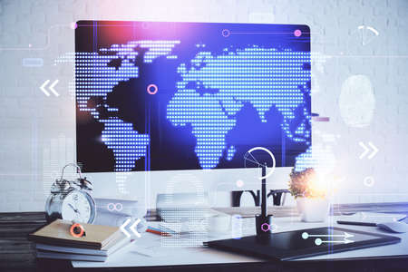 Double exposure of desktop with computer and world map hologram. International data network concept.