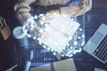 Multi exposure of writing hand on background with brain hologram. Concept of learning.の写真素材