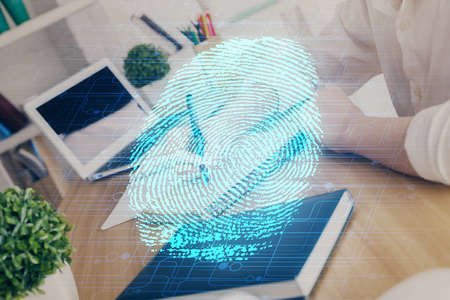 Blue fingerprint hologram over hands taking notes background. Concept of security. Double exposureの写真素材