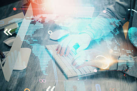 Double exposure of world map hologram with man working on computer on background. Concept of worldwideweb.の写真素材