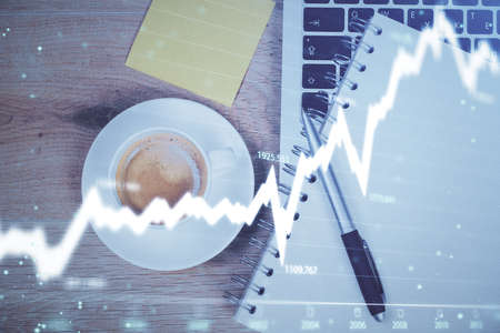 Double exposure of forex chart drawing over table background with computer. Concept of financial...