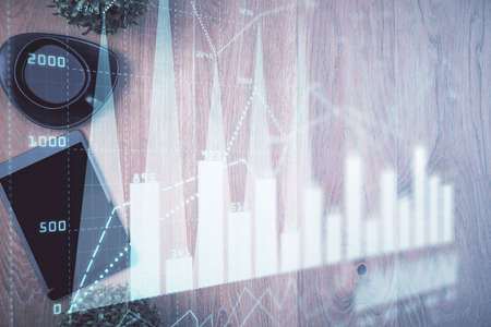 Multi exposure of financial chart hologram over desktop with phone. Top view. Mobile trade platform...