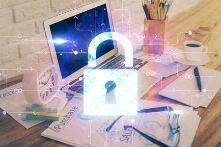 Double exposure of desktop with computer and lock icon hologram. Concept of data safety.