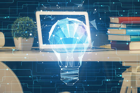 Computer on desktop in office with bulb icon hologram. Double exposure. Concept of idea.