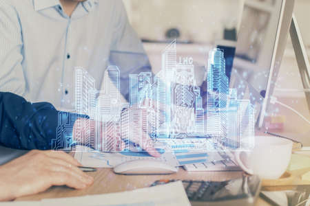 High tech city drawing with businessman working on computer on background. Smartcity concept. Double...
