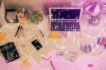 Double exposure of forex chart drawing over table background with computer. Concept of financial...