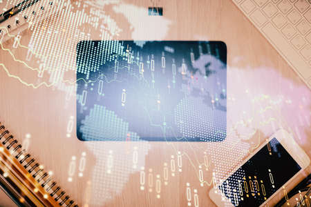 Double exposure of forex graph hologram over desktop with phone. Top view. Mobile trade platform...