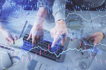 Double exposure of man and woman working together and forex graph hologram drawing. Financial analysis concept. Computer background. Top View.の写真素材