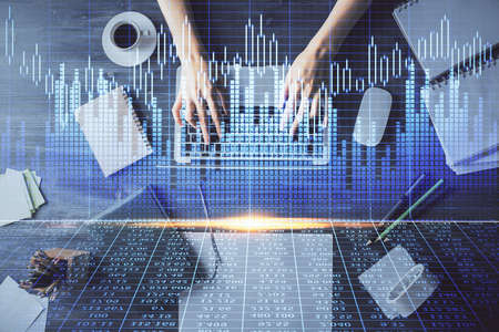 Multi exposure of woman hands working on computer and forex chart hologram drawing. Top View....