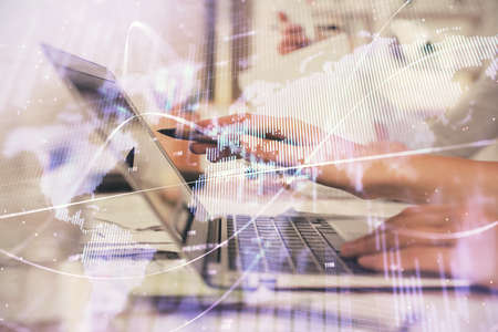 Multi exposure of woman hands typing on computer and financial graph hologram drawing. Stock market...