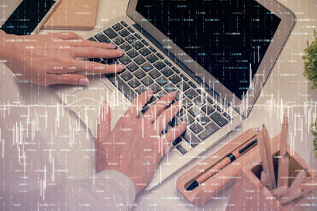 Double exposure of woman hands typing on computer and forex chart hologram drawing. Stock market...
