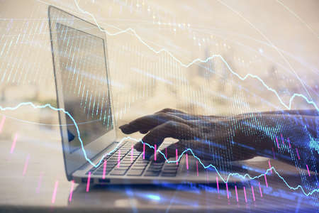 Double exposure of woman hands typing on computer and forex chart hologram drawing. Stock market...