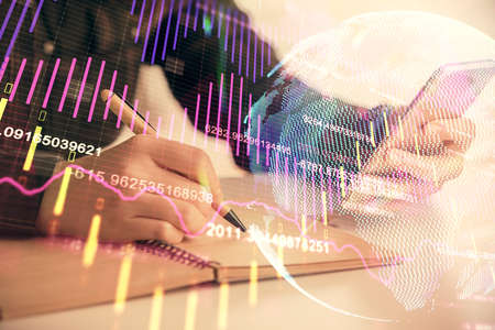 Double exposure of forex graph sketch hologram and woman holding and using a mobile device. Stock...