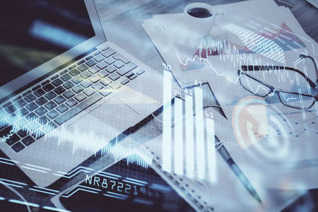 Computer on desktop in office with technology theme hologram. Double exposure. Tech concept.