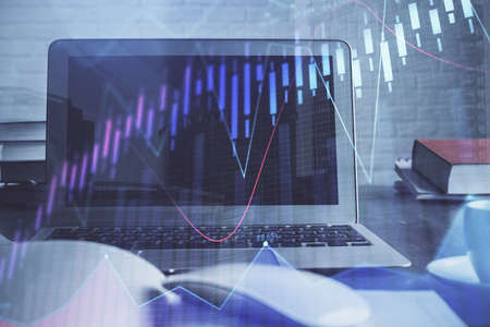 Stock market graph on background with desk and personal computer. Double exposure. Concept of...
