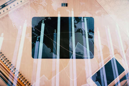 Double exposure of forex graph hologram over desktop with phone. Top view. Mobile trade platform concept.の写真素材
