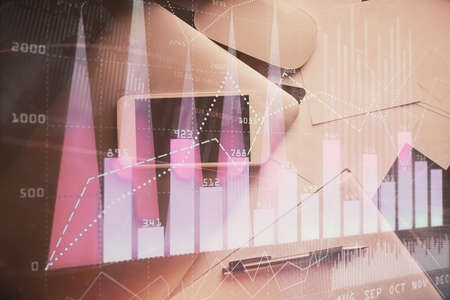 Multi exposure of forex graph hologram over desktop with phone. Top view. Mobile trade platform...
