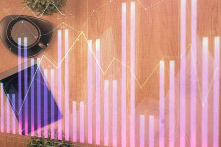 Multi exposure of financial chart hologram over desktop with phone. Top view. Mobile trade platform...