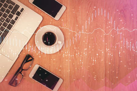 Double exposure of forex chart hologram over desktop with phone. Top view. Mobile trade platform...