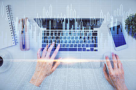 Double exposure of woman hands working on computer and forex chart hologram drawing. Top View. Financial analysis concept.の写真素材