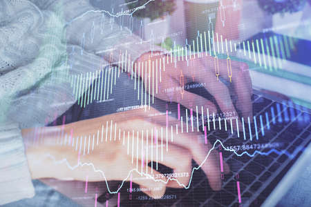 Double exposure of woman hands typing on computer and forex chart hologram drawing. Stock market invest concept.の写真素材
