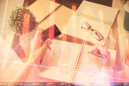 Multi exposure of woman on-line shopping holding a credit card and financial graph drawing. Stock...