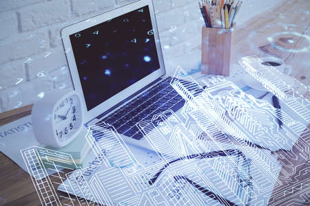 Desktop computer background in office and big town buildings hologram drawing. Double exposure....