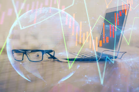 Stock market chart hologram drawn on personal computer background. Double exposure. Concept of investment.の写真素材