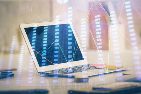Forex market chart hologram and personal computer background. Double exposure. Concept of...