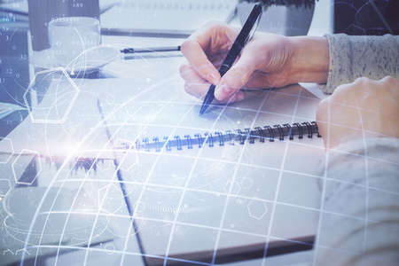 Multi exposure of hands making notes with world map hologram and data theme icons. Concept of global...