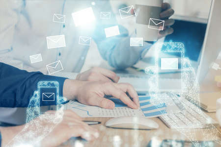 Envelop holograms with businessman working on computer on background. E-mail concept. Multi...