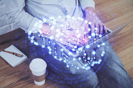 Businessman with computer background with brain theme hologram. Concept of brainstorm. Multi...