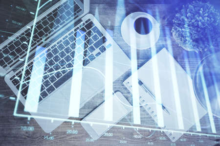 Financial market graph and top view computer on the desktop background. Double exposure. Investment...