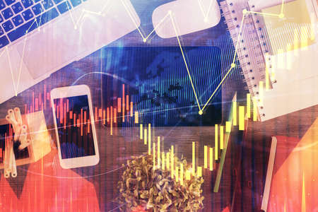 Double exposure of forex chart hologram over desktop with phone. Top view. Mobile trade platform...