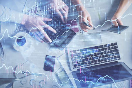 Double exposure of man and woman working together and financial chart hologram drawing. market...