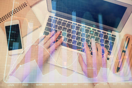 Double exposure of woman hands working on computer and forex graph hologram drawing. Top View. Financial analysis concept.の写真素材