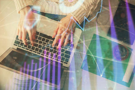 Double exposure of woman hands working on computer and forex chart hologram drawing. Top View....