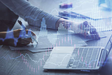 Double exposure of businesswoman hands typing on computer and forex chart hologram drawing....
