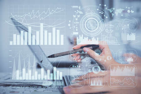 Multi exposure of woman hands typing on computer and financial graph hologram drawing. Stock market...