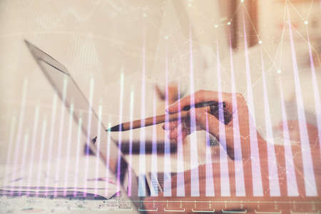 Multi exposure of woman hands typing on computer and financial graph hologram drawing. Stock market analysis concept.の写真素材