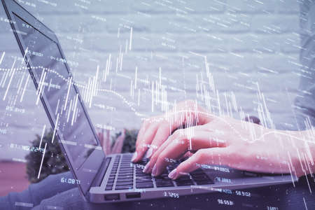 Multi exposure of woman hands typing on computer and forex chart hologram drawing. Stock market...