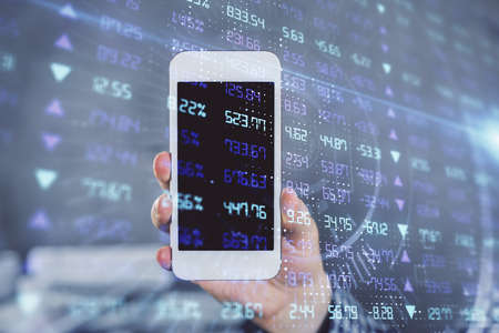Double exposure of man's hands holding and using a digital device and forex graph drawing. Financial...
