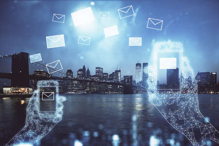 Double exposure of envelop hologram flying from gadget and city view background. Concept e-mail.の写真素材