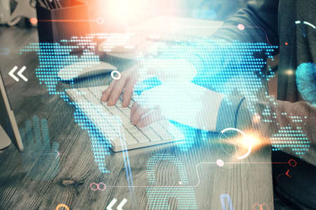 Multi exposure of world map hologram with man working on computer on background. Concept of...