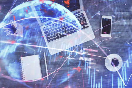Double exposure of forex chart drawing over table background with computer. Concept of financial...